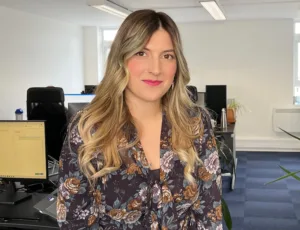 Person in colourful blouse standing in an office