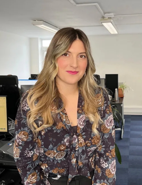 Person in colourful blouse standing in an office