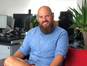 Person in blue shirt sitting on a sofa in an office