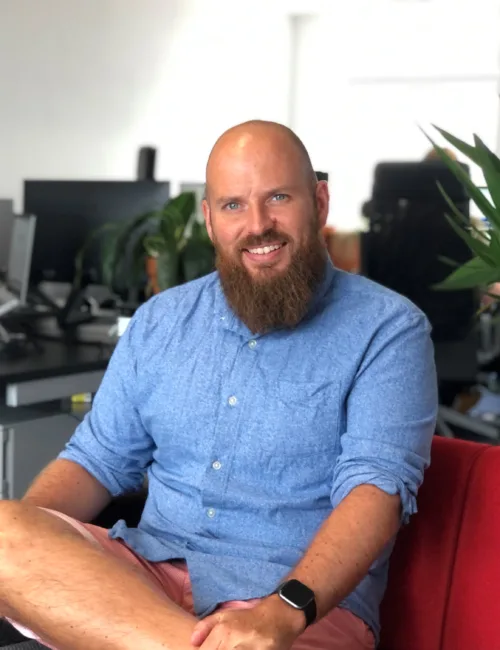 Person in blue shirt sitting on a sofa in an office