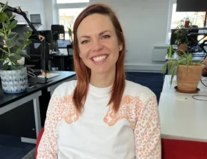 Person in white sweatshirt sitting on a sofa in an office