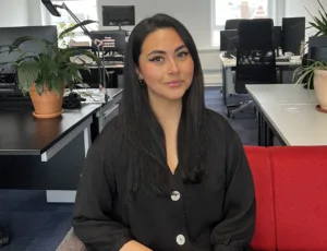 Person in black dress sitting on a sofa in an office