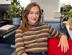 Person in stripped sweater sitting on a sofa in an office
