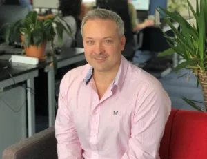 Person in pink shirt sitting on a sofa in an office